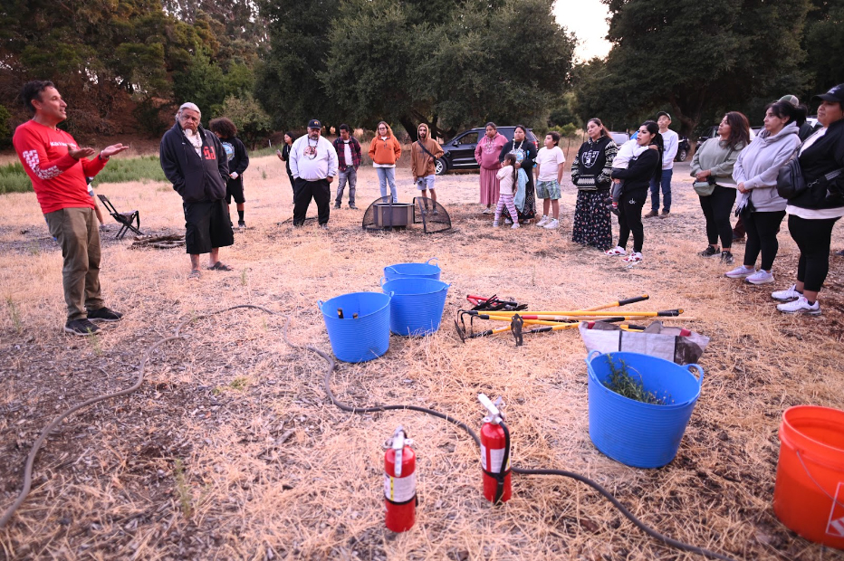 Mike Wilcox (far left) talks to Joey Torres (next to Mike) and other tribal members at the Muwekma Native plants garden on Stanford campus. Photo by Marina Luccioni.