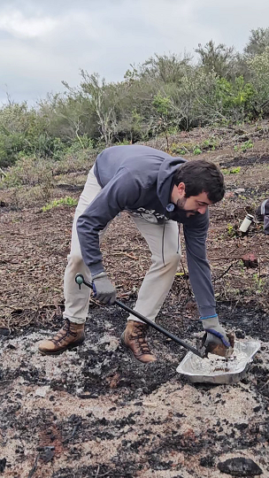 Amaury takes a soil core from a burn pile