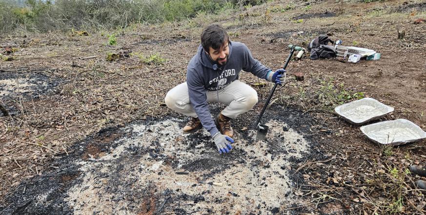 Amaury prepares to take a soil core from a burn pile