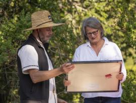 Jorge Ramos presenting Liz Hadly a framed photo of Jasper Ridge Biological Preserve